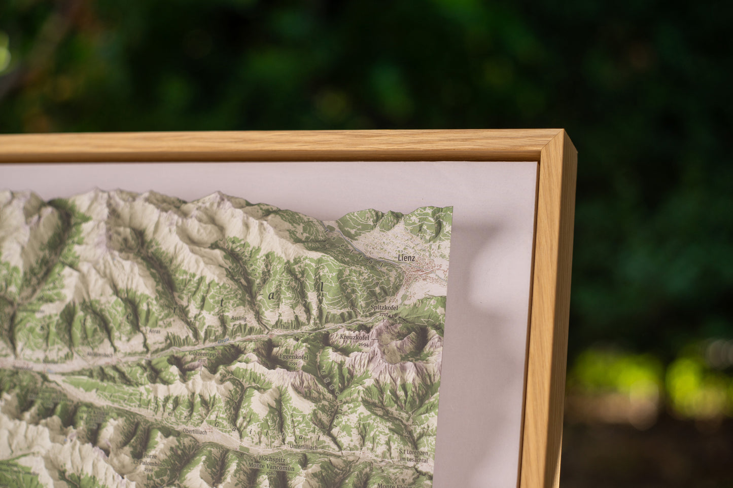 Dettaglio della MountainCarto Edizione Incorniciata Toscana con cornice artigianale in rovere naturale e superficie opaca anti-riflesso / Detail of the MountainCarto Tuscany Framed Edition featuring a handcrafted natural oak frame and glare-free matte surface
